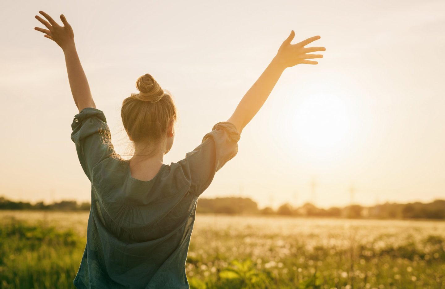female teen girl stand feel freedom with arms stretched to the sky, sunset light